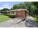 Side view of brick home, showcasing the driveway and landscaping at 135 5Th Ave, Jonesboro, GA 30236