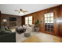 Comfortable living room with wood-paneled walls, a brick fireplace, neutral furnishings, and natural light at 3409 Shorelake Dr, Tucker, GA 30084