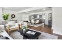 Open-concept living room with hardwood floors, bright windows, and seamless access to dining and kitchen at 1258 Campbellton Sw Rd, Atlanta, GA 30310
