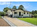 Charming home with a paved driveway and a well-maintained lawn with mature trees at 4020 Ester Sw Dr, Atlanta, GA 30331