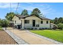 Home featuring a concrete driveway with stone trim, manicured lawn, and a wrought-iron fence at 4020 Ester Sw Dr, Atlanta, GA 30331