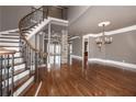 Elegant foyer with a curved staircase, hardwood floors, stone column and crown molding at 297 Collegiate Dr, Powder Springs, GA 30127