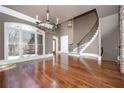 Spacious living room with gleaming hardwood floors, large windows, and a grand staircase and stone fireplace at 297 Collegiate Dr, Powder Springs, GA 30127