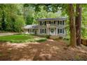 Traditional home featuring a well-maintained lawn, wood siding, blue shutters, and mature trees at 1610 Old Mill Xing, Marietta, GA 30062