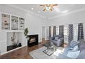 Cozy living room featuring a fireplace, built-in shelving, hardwood floors, and neutral décor at 4021 Melvin Sw Dr, Atlanta, GA 30331