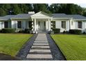 Charming front entrance with a stone walkway, manicured lawn, and a classic portico supported by elegant white columns at 4095 N Broadland Nw Rd, Atlanta, GA 30342
