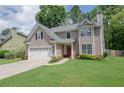 Inviting home featuring a lush green lawn, a two-car garage, and classic architectural details at 2427 Camata, Marietta, GA 30066