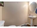 Cozy half bathroom featuring a pedestal sink, round mirror, and neutral wall color at 3931 Fireoak Dr, Decatur, GA 30032