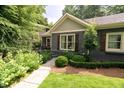 Beautifully landscaped front yard with mature trees, shrubs, and lush grass, and covered porch with seating at 796 Piedmont Ne Way, Atlanta, GA 30324