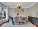 Elegant dining room with natural light, chandelier, and seating for six at 1105 Sterling Brooke Dr, Alpharetta, GA 30022