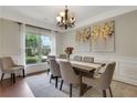 Elegant dining room with natural light, chandelier, and seating for six at 1105 Sterling Brooke Dr, Alpharetta, GA 30022