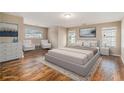 Spacious main bedroom with a king-size bed, hardwood floors, and plenty of natural light from the large windows at 555 Sydney Crest Ln, Lawrenceville, GA 30046