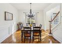 Traditional dining room with dark wood table, chandelier, and view of front yard at 7115 Doncaster Ct, Cumming, GA 30040