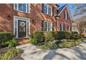 Charming front entrance with manicured landscaping and a decorative wreath on the dark wood door at 7115 Doncaster Ct, Cumming, GA 30040