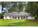 Charming single-story home with a well-maintained lawn, black shutters, and an inviting front porch at 2487 Highland Se Dr, Conyers, GA 30013