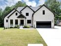 Charming white brick home boasts a well-manicured lawn and a modern, dark garage door at 3562 Clubland Dr, Marietta, GA 30068