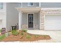 Close-up of front entrance with stone accents, a black front door, and fresh landscaping at 4778 Moonstone Trce, Kennesaw, GA 30144