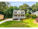 Inviting two-story home with a covered front porch, mature trees, and a beautifully maintained yard at 2401 Stockton Dr, Marietta, GA 30066