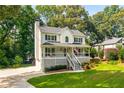 Lovely two-story home showcasing a welcoming porch, complemented by a green lawn and mature trees at 2401 Stockton Dr, Marietta, GA 30066