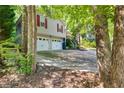 Wide driveway leading to a two-car garage, framed by lush trees and landscaping at 224 Amy Blvd, Temple, GA 30179