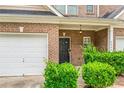 Close up of the brick townhome with a garage, front door and manicured landscaping at 2555 Flat Shoals Rd # 2006, Atlanta, GA 30349
