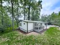 Rear exterior of home has a deck, a well manicured lawn and a wooded backdrop at 337 Theodore Cox Cir, Canton, GA 30114