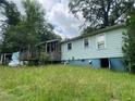 The backyard view reveals a wooden deck and light blue siding, complemented by an overgrown lawn at 2096 Boar Tusk Ne Rd, Conyers, GA 30012