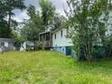 The backyard view reveals a wooden deck and light blue siding, complemented by an overgrown lawn at 2096 Boar Tusk Ne Rd, Conyers, GA 30012
