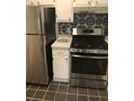 Kitchen featuring stainless steel appliances, white cabinets, and black-and-white backsplash, ideal for cooking at 2840 Peachtree Road Nw Nw Rd # 306, Atlanta, GA 30305