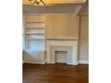 Living room with a cozy fireplace, custom built-in shelving, hardwood floors, and elegant crown molding at 2840 Peachtree Road Nw Nw Rd # 306, Atlanta, GA 30305