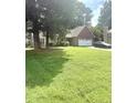 Lovely single-story home with neat landscaping, mature trees, and a brick facade two car garage at 7133 Babbling Brook Dr, Jonesboro, GA 30236