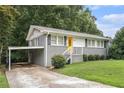 Charming single story home with gray brick and siding, grassy front lawn and updated stairs to the yellow front door at 232 Whitworth Sw Dr, Atlanta, GA 30331