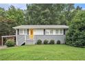 Charming single story home with gray brick and siding, grassy front lawn and updated stairs to the yellow front door at 232 Whitworth Sw Dr, Atlanta, GA 30331