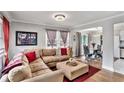 Inviting living room featuring a large sectional, hardwood floors, modern lighting, and an adjacent dining area at 232 Whitworth Sw Dr, Atlanta, GA 30331