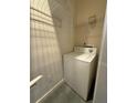Simple laundry area with a white washing machine and wire shelving at 395 Central Park Ne Pl # 610, Atlanta, GA 30312