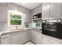 Classic kitchen with gray cabinets, granite countertops, tile backsplash, and updated appliances at 4149 Indian Lake Cir, Stone Mountain, GA 30083
