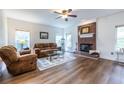 Inviting living room featuring a cozy brick fireplace and gleaming hardwood floors at 616 Piping Rock Pt, Lawrenceville, GA 30043