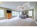 Expansive main bedroom with tray ceiling and natural light from large windows at 616 Piping Rock Pt, Lawrenceville, GA 30043