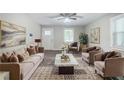 Cozy living room featuring neutral paint, ample seating, decorative art, a ceiling fan, and natural light at 10150 Puckett St, Covington, GA 30014