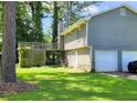 Features a spacious wooden deck, lush green lawn, and a convenient two-car garage, ideal for outdoor living and parking at 9218 River Chase Way, Jonesboro, GA 30238