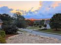 Picturesque neighborhood view with a stunning sunset in the background at 215 Settindown Ct, Roswell, GA 30075