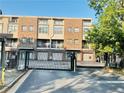 Brick condo building features garages, secured gate, landscaping and mature trees at 238 Walker Sw St # 22, Atlanta, GA 30313