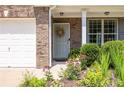 A cozy front entrance with a light blue door, surrounded by colorful flower beds, and lush greenery at 167 Diamond Ridge Ave, Canton, GA 30114