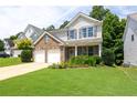 Inviting two-story home featuring a brick facade, gray shutters, a two-car garage, and lush green lawn at 167 Diamond Ridge Ave, Canton, GA 30114
