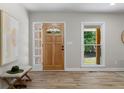 Bright entryway with a wood-look front door, adjacent sidelight, and a bench with hat at 6456 Wright Ne Rd, Atlanta, GA 30328