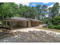 A single-story home with a spacious attached carport, surrounded by lush greenery and mature trees at 6456 Wright Ne Rd, Atlanta, GA 30328