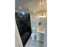 Modern bathroom featuring a sleek black-tiled shower with rainfall showerhead and updated vanity at 4356 Rockbridge Rd, Stone Mountain, GA 30083