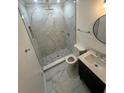Elegant bathroom with marble-tiled shower, modern vanity, and stylish round mirror at 4356 Rockbridge Rd, Stone Mountain, GA 30083