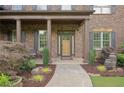 Inviting front porch with decorative columns, stone accents, and manicured landscaping at 4547 Meadow Green Nw Ln, Acworth, GA 30101