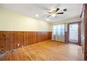 Cozy bedroom with hardwood floors, wood paneling, and a ceiling fan at 1191 S Burnt Hickory Rd, Douglasville, GA 30134